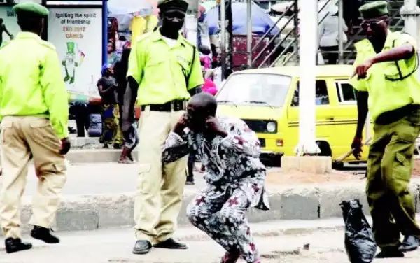 KAI Officials Pictured Asking An Elderly Man To Frog Jump For Not Using The Pedestrian Bridge In Lagos (Photo)